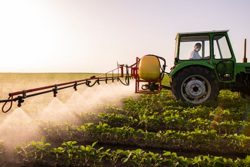 Farmer in Tractor Spraying Pesticides