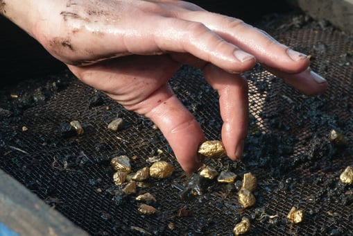 Picking up gold nuggets from the dirt
