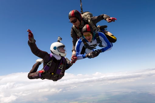 Three smiling people skydiving together