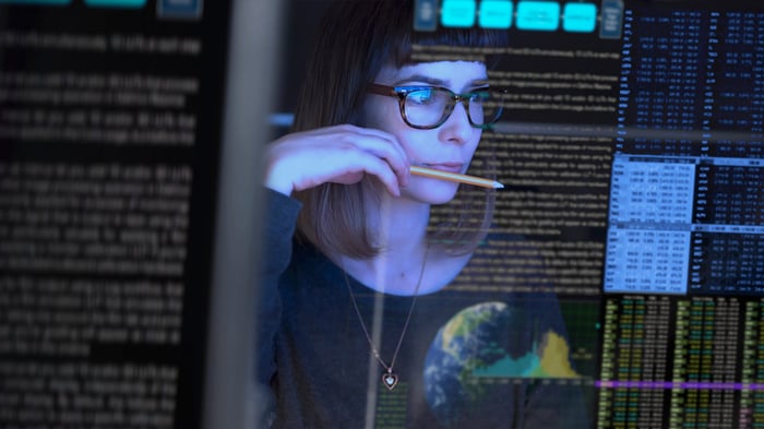 An IT professional checks data on a computer screen.