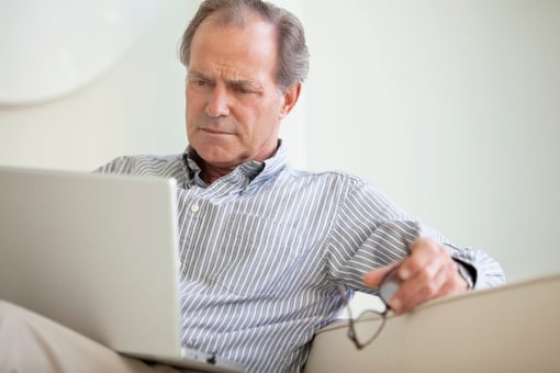 Serious Senior Using Laptop Social Security Getty