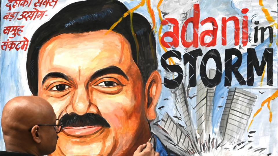 Art school teacher Sagar Kambli gives final touches to a painting of Indian businessman Gautam Adani highlighting the ongoing crisis of the Adani group in Mumbai on February 3, 2023.