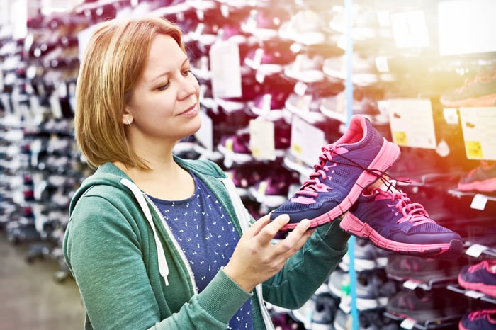 A person shopping for sneakers in a shoe store.