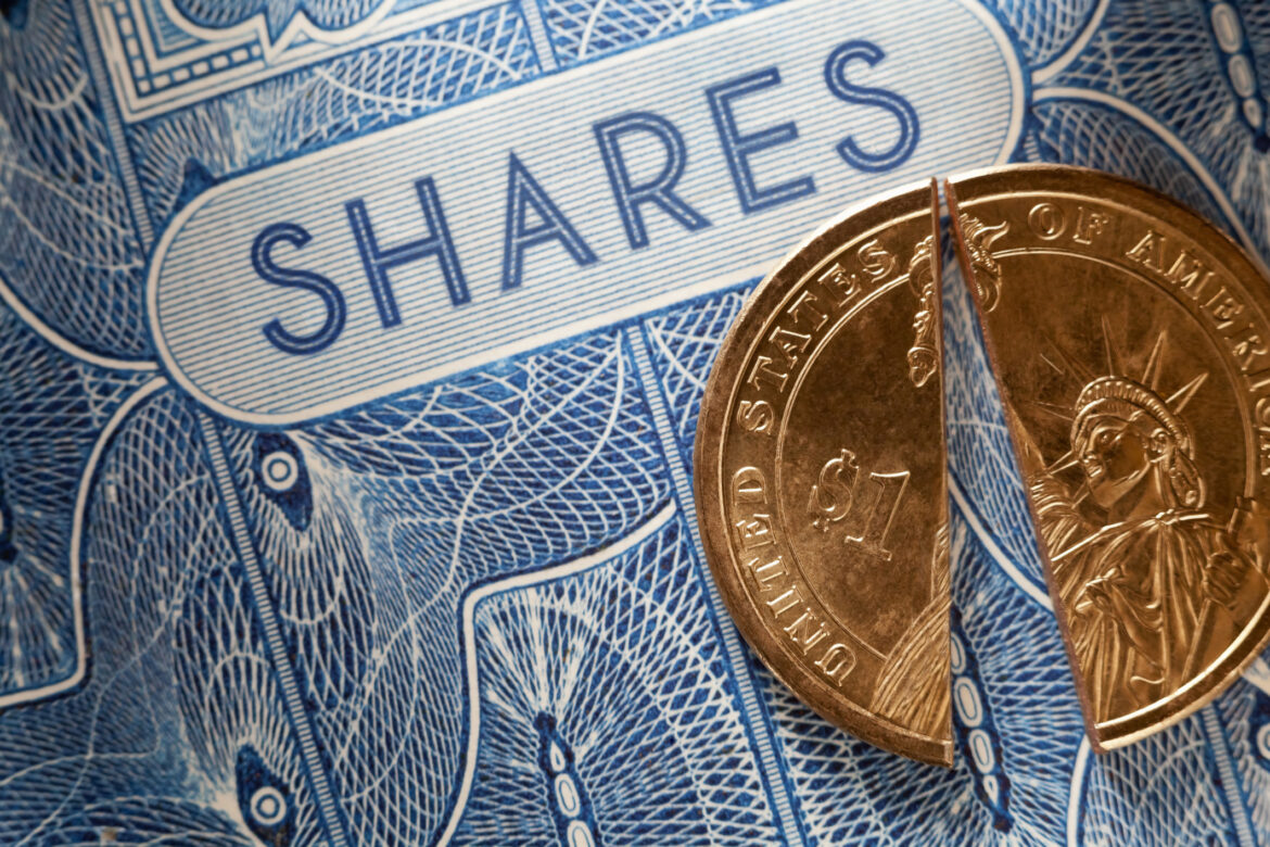 a-split-coin-on-top-of-paper-shares.jpg