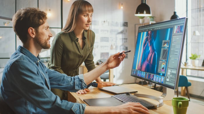 Two designers digitally edit a photo.