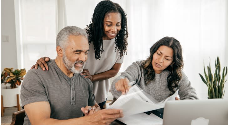 A woman and her father go over her estate plan with an estate planning attorney. 