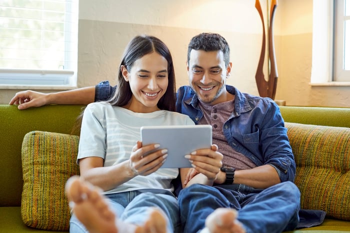 Pair of individual investors looking at a device.