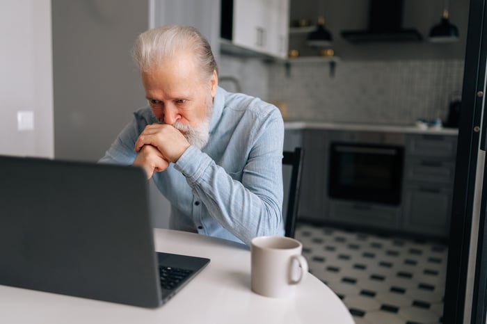 A person with a serious expression at a laptop.