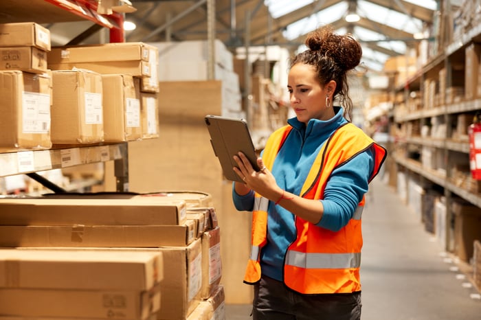 A person checks package inventory in a warehouse. 