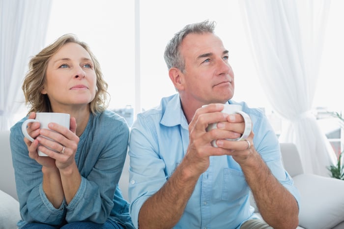 Two people holding coffee mugs.