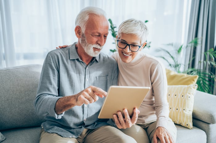 Two older people looking at a book. 