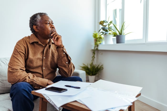 A person at a table looking toward a window.