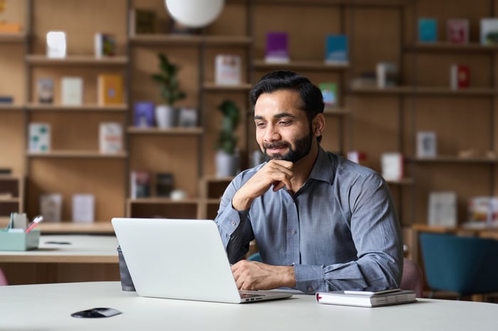 Person sitting at a desk using a laptop.