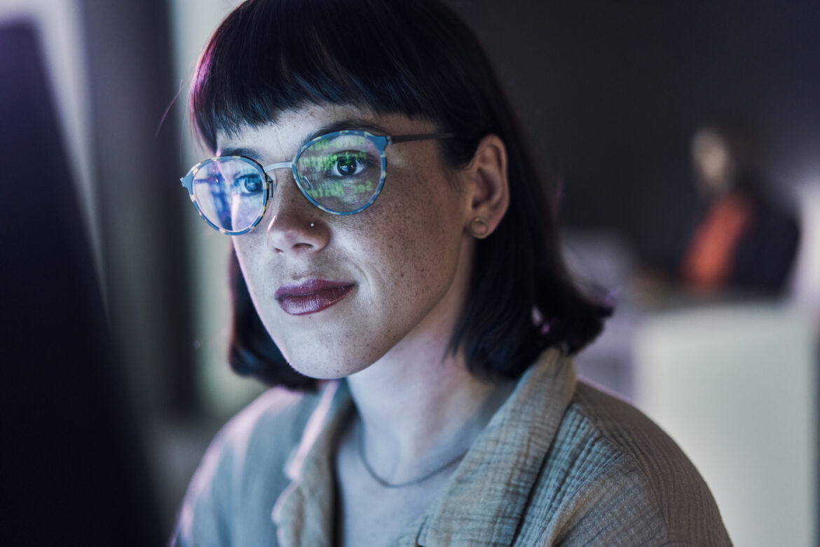 a-business-person-looking-at-charts-on-a-computer-with-light-reflecting-off-their-glasses.jpg