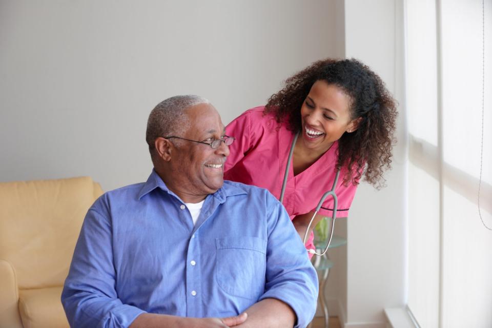 A nurse checking in on a seated patient. 