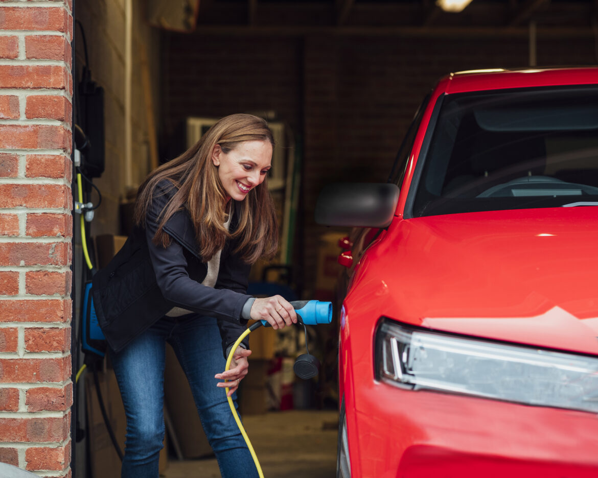 a-person-plugging-a-charger-into-an-electric-car.jpg