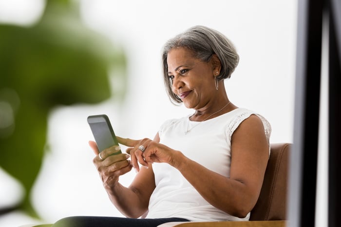 A smiling person holding a phone.