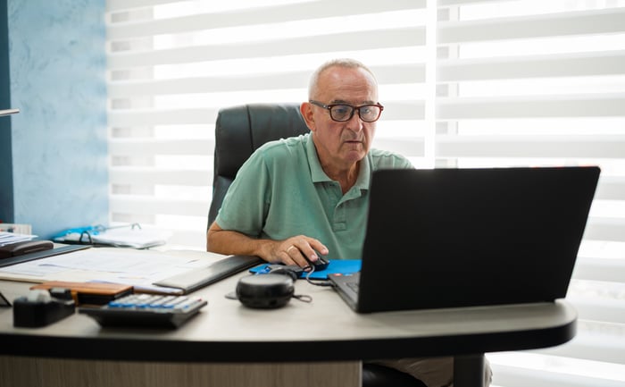 A person at a desk with a laptop in front of them.