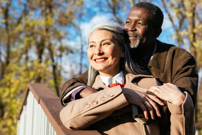 Two people standing outside and hugging.