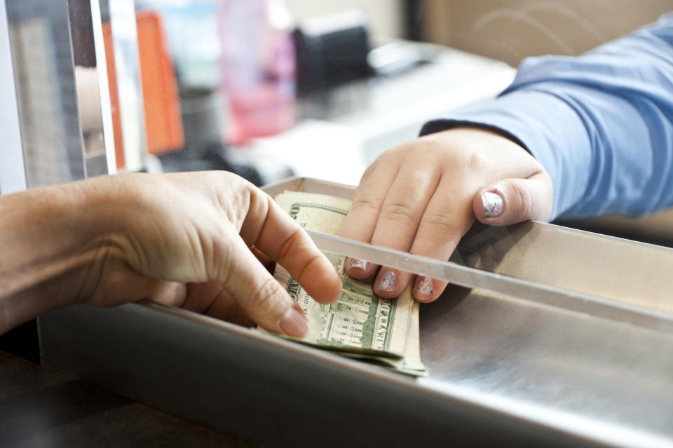 women hands getting cash in a bank teller