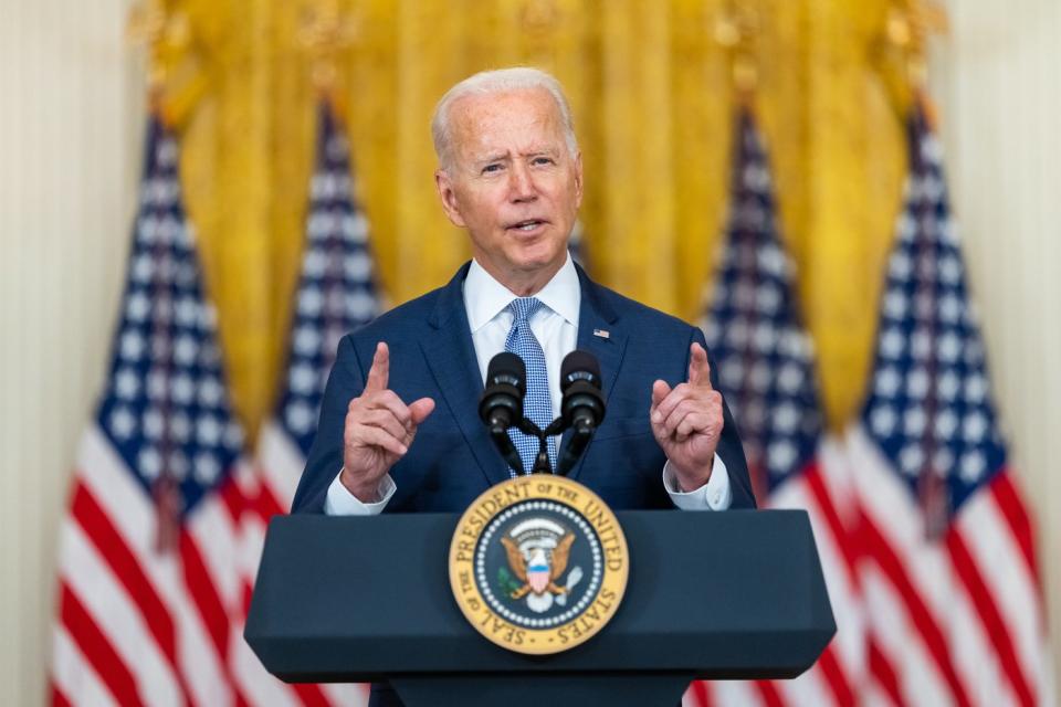 Joe Biden speaking with reporters in the East Room of the White House. 