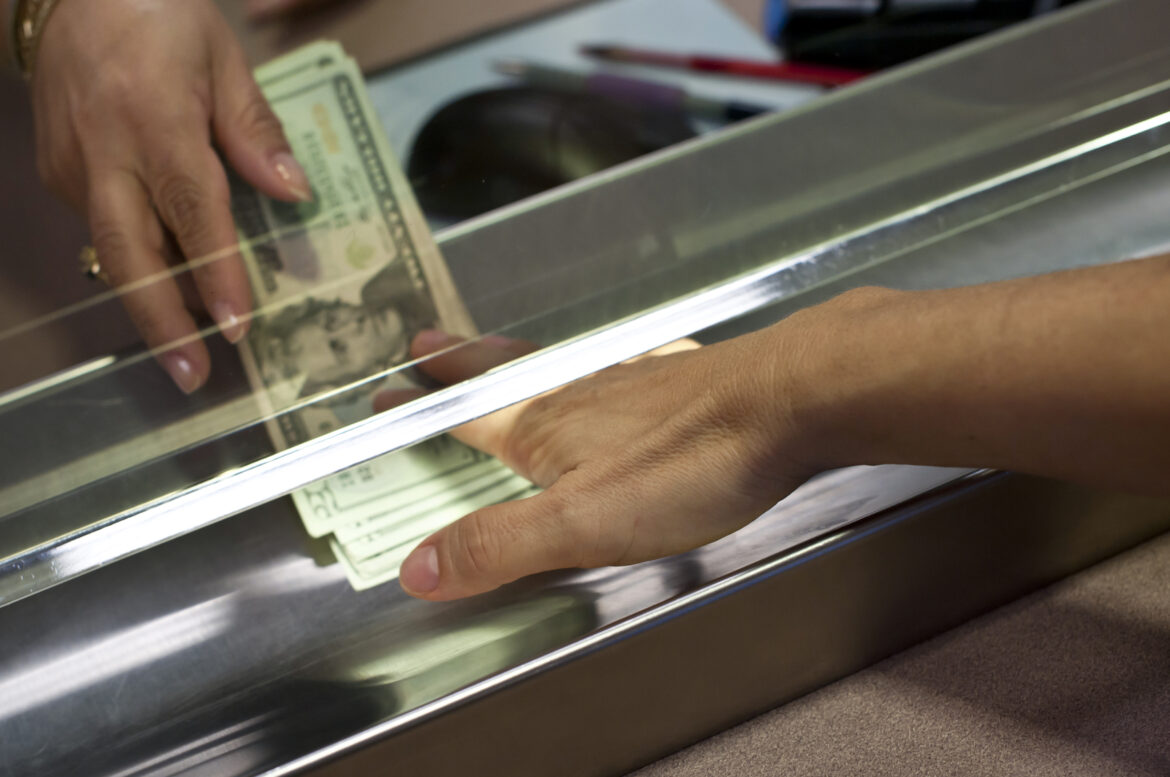 american-currency-being-exchanged-across-a-bank-teller-window.jpg